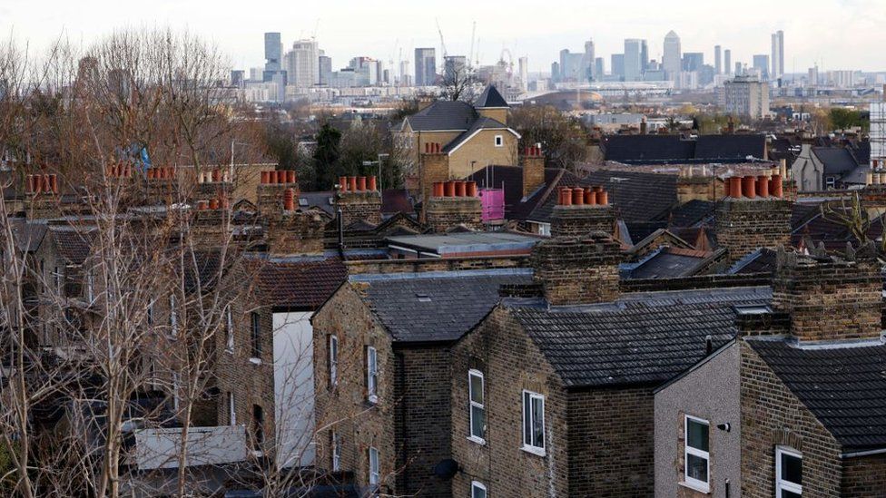 File image showing an aerial view of streets and houses in London, with the city skyline behind.