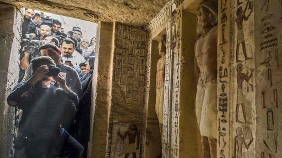 Journalists enter a newly-discovered tomb at the Saqqara necropolis, 30 kilometres south of the Egyptian capital Cairo