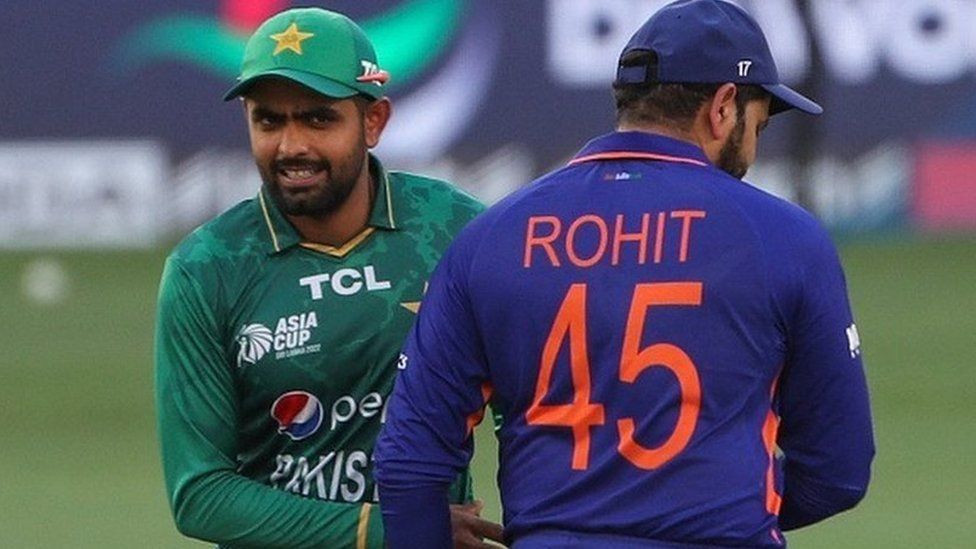 Pakistan's captain Babar Azam (L) walks past India's captain Rohit Sharma during the toss before the start of the Asia Cup Twenty20 international cricket Super Four match between India and Pakistan at the Dubai International Cricket Stadium in Dubai on September 4, 2022.