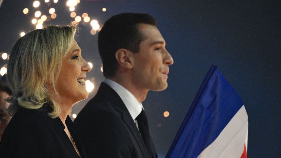 President of the French far-right Rassemblement National (RN) group at the National Assembly Marine Le Pen (L) and RN President and electoral list leader Jordan Bardella sing the national anthem at the end of a meeting to launch the RN's campaign for upcoming European elections, in Marseille, southeastern France, on March 3, 2024