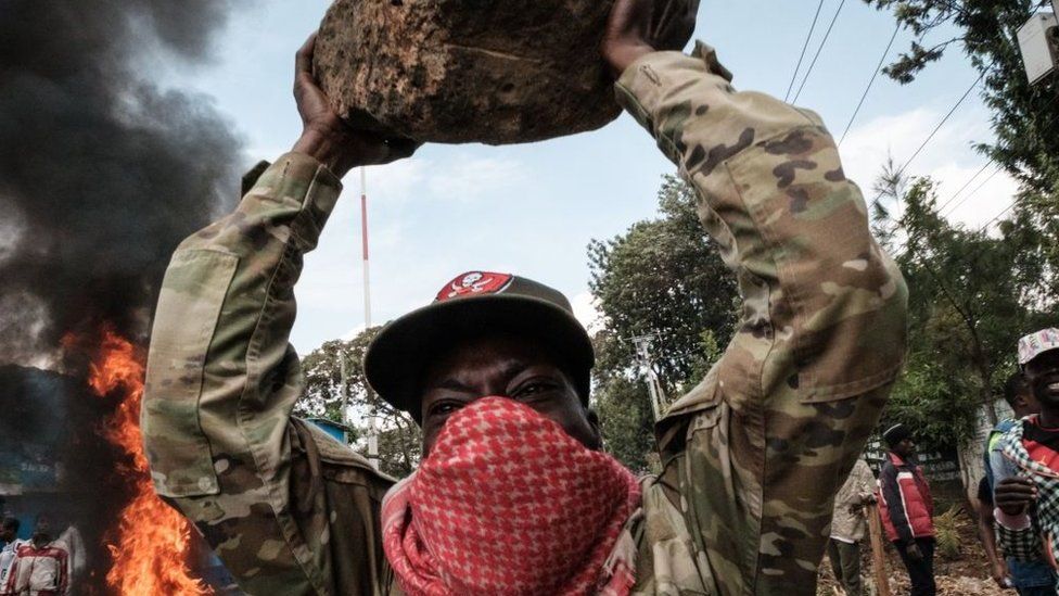 A protester gestures with a rock during a mass rally called by the opposition leader Raila Odinga who claims the last Kenyan presidential election was stolen from him and blames the government for the hike of living costs in Kibera, Nairobi on 20 March.