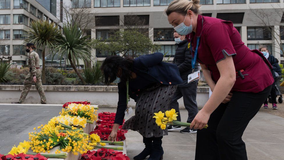 NHS staff lay flowers outside St. Thomas's hospital in central London to remember those who have died from the Coronavirus as part of the National Day of Reflection