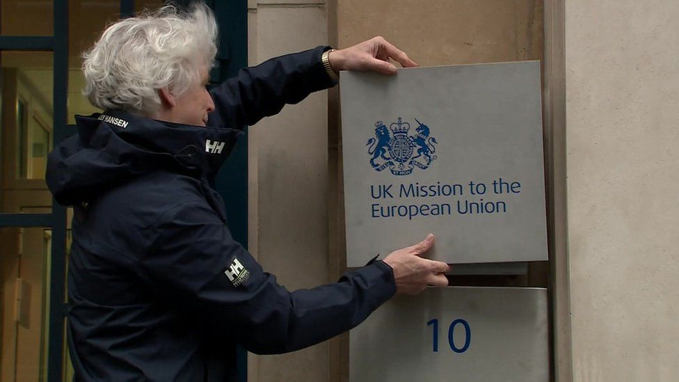 A man changing the sign outside the UK government delegation to the EU, which changed its name to UK Mission to the European Union