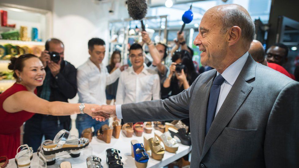 French right-wing Les Republicains (LR) party's mayor of Bordeaux and candidate for the LR party primary Alain Juppe (R) shakes hands during a visit to the Chinese community in Aubervilliers, near to Paris, on September 8, 2016.