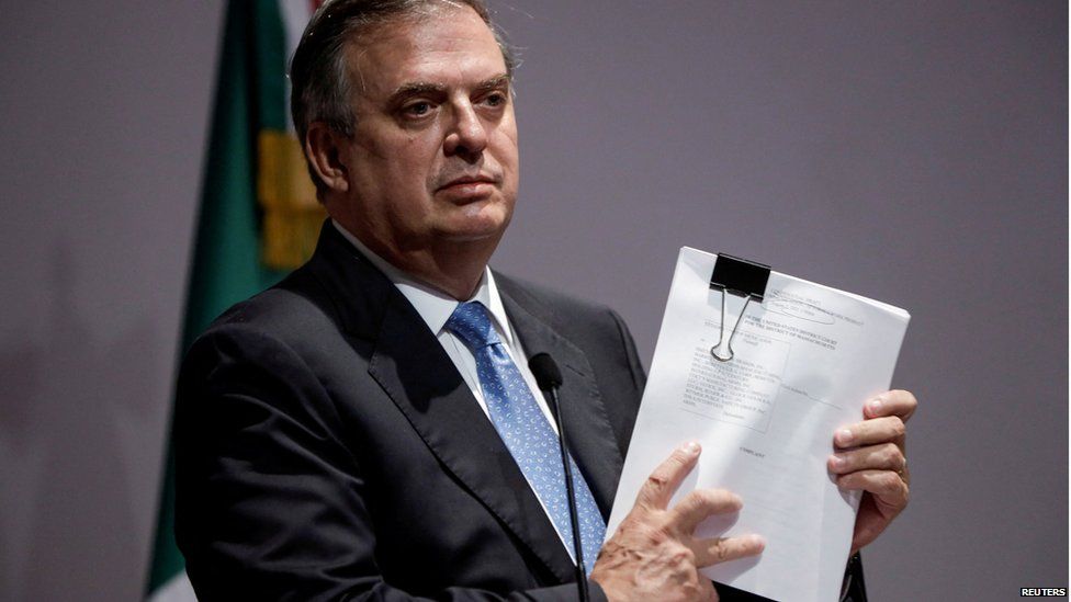 Mexican Foreign Minister Marcelo Ebrard holds documents during a news conference announcing a lawsuit against American gun makers