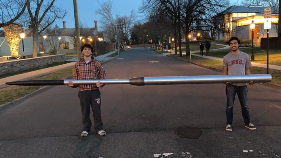 Students Joshua and Saad Mirza hold the space rocket they designed and built