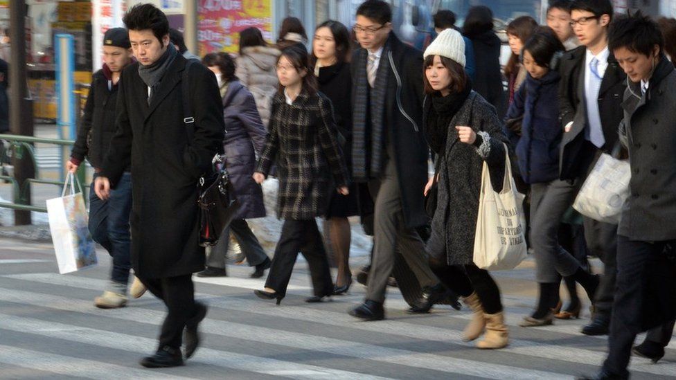 Businessmen and women cross the road in Tokyo