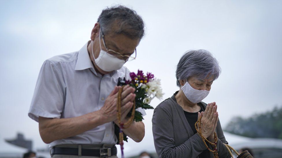 An elderly couple prays for victims in front of a cenotaph at Peace Memorial Park in Hiroshima