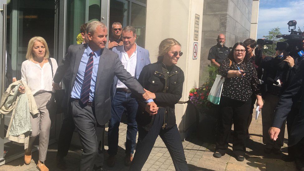 Dennis Oland leaves court on 19 July, accompanied by family.
