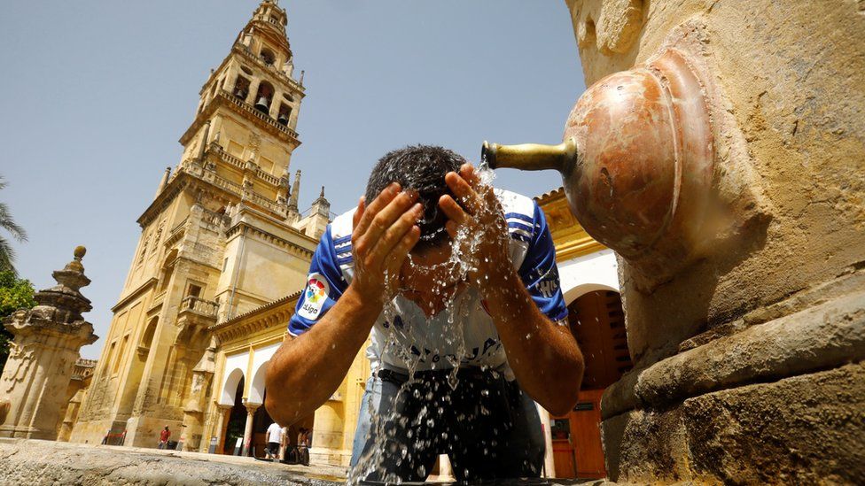 Мужчина охлаждается в фонтане в жаркий день в Кордове, южная Испания, 13 августа 2021 года.