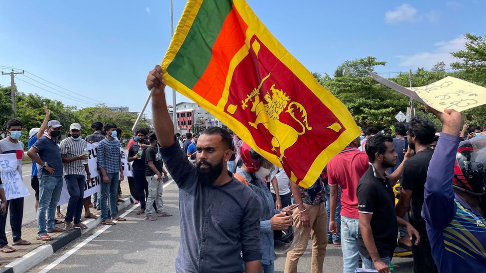 A protester holds up the Sri Lanka flag amid a crowd of demonstrators in Colombo