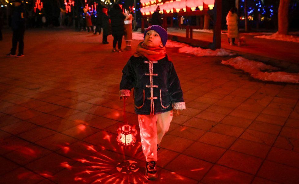 A child carrying a lantern visits a park during the Lantern festival in Beijing