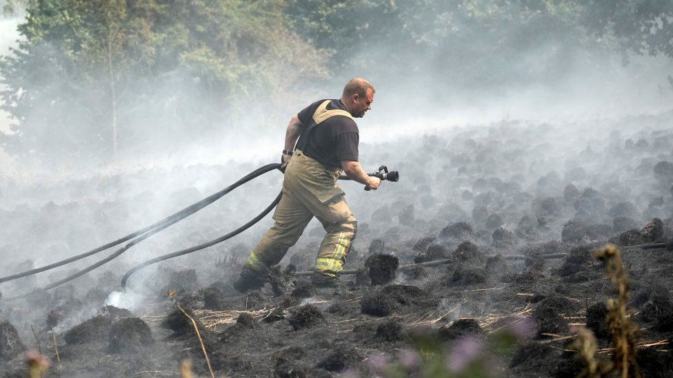 Firefighters contain a wildfire that encroached on nearby homes in the Shiregreen area of Sheffield, 20 July 2022