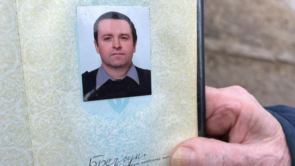 Serhii's mother holds his passport with his photo in