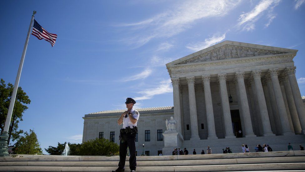 A police officer is seen outside the US Supreme Court after it was announced that the court will allow a limited version of President Donald Trump's travel ban to take effect June 26, 2017 in Washington, DC. T