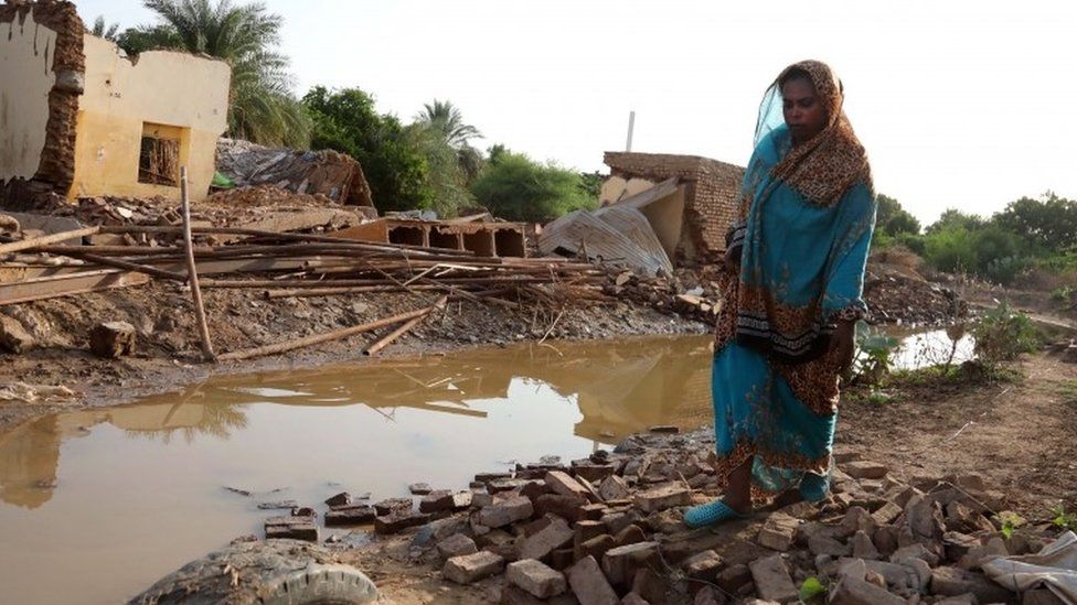 A Sudanese woman walks amid the rubble of houses destroyed following heaving floods, in Geli, some 40 km north of Khartoum, Sudan, 25 August 2019