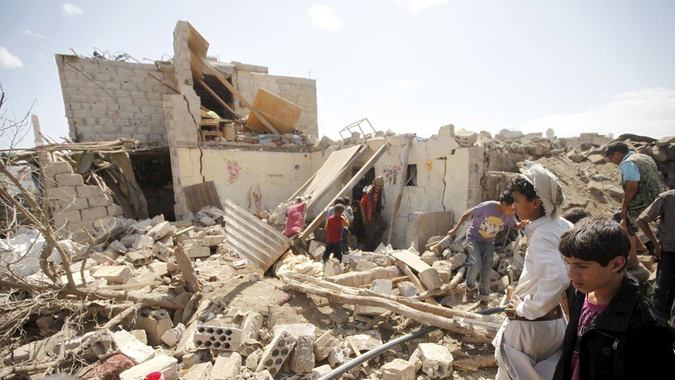 People inspect damage at a house after it was destroyed by a Saudi-led air strike in Yemen's capital Sanaa, February 25, 2016.