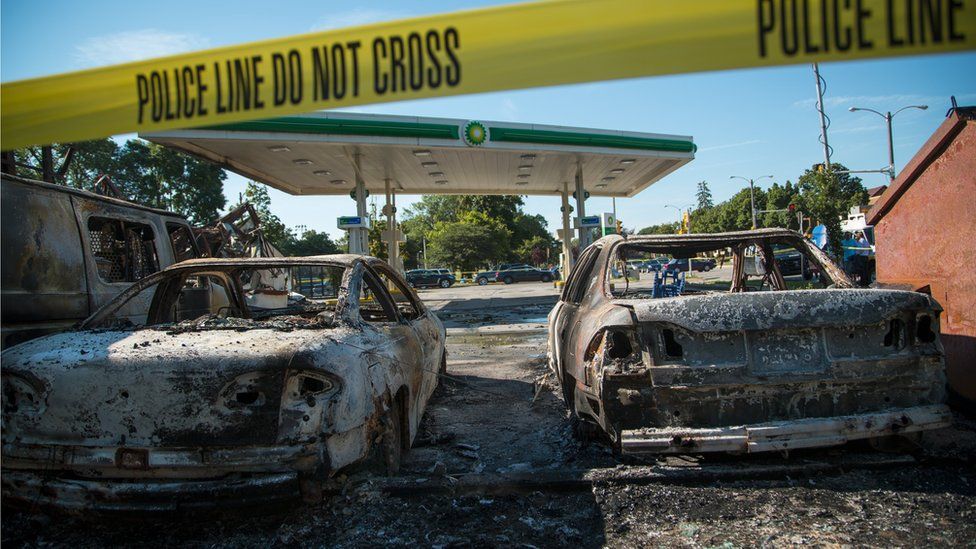 Cars stand burned in the lot of the BP gas station after rioters clashed with the Milwaukee Police Department protesting an officer involved killing August 14, 2016 in Milwaukee, Wisconsin