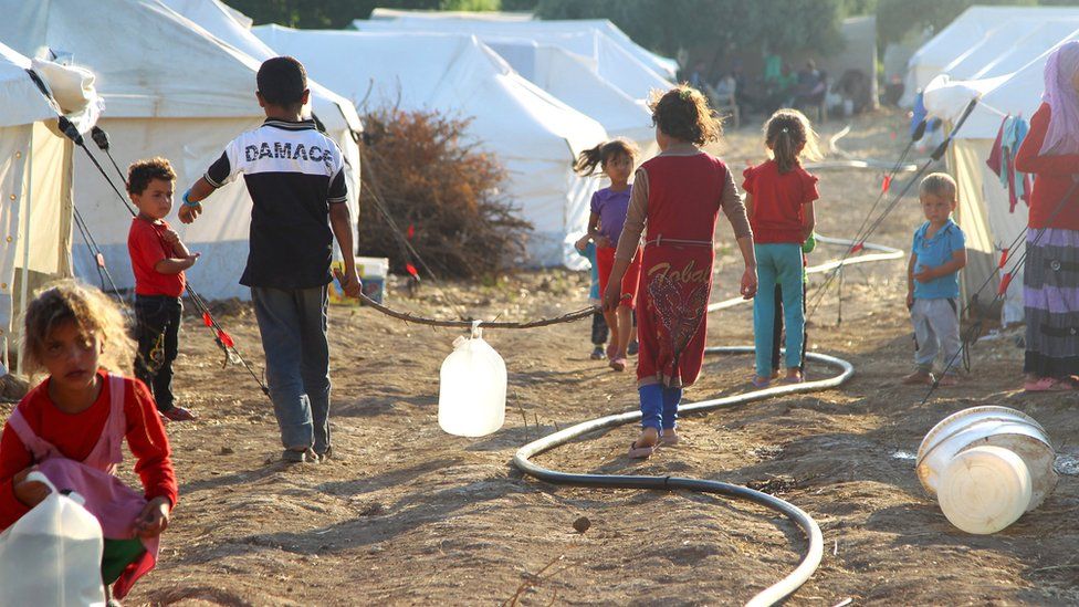 Children walk inside a camp for internally displaced persons near the Syrian-Turkish border in Salqin, Idlib countryside, Syria, in June 2015