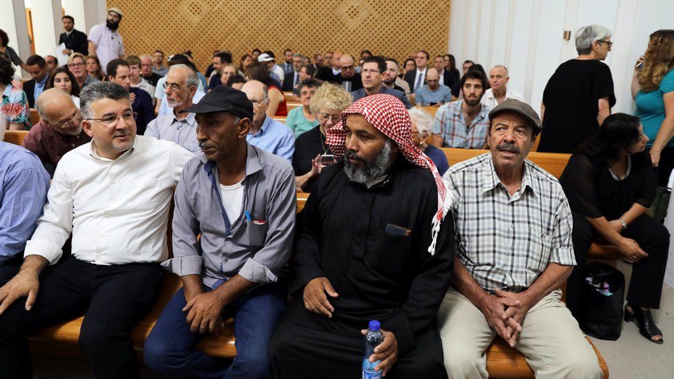 Residents of Khan al-Ahmar sit inside the Israeli Supreme Court building in Jerusalem on 1 August 2018
