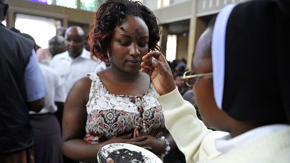 A Kenyan Catholic has ashes applied to her forehead in the form of a cross during a Lent mass