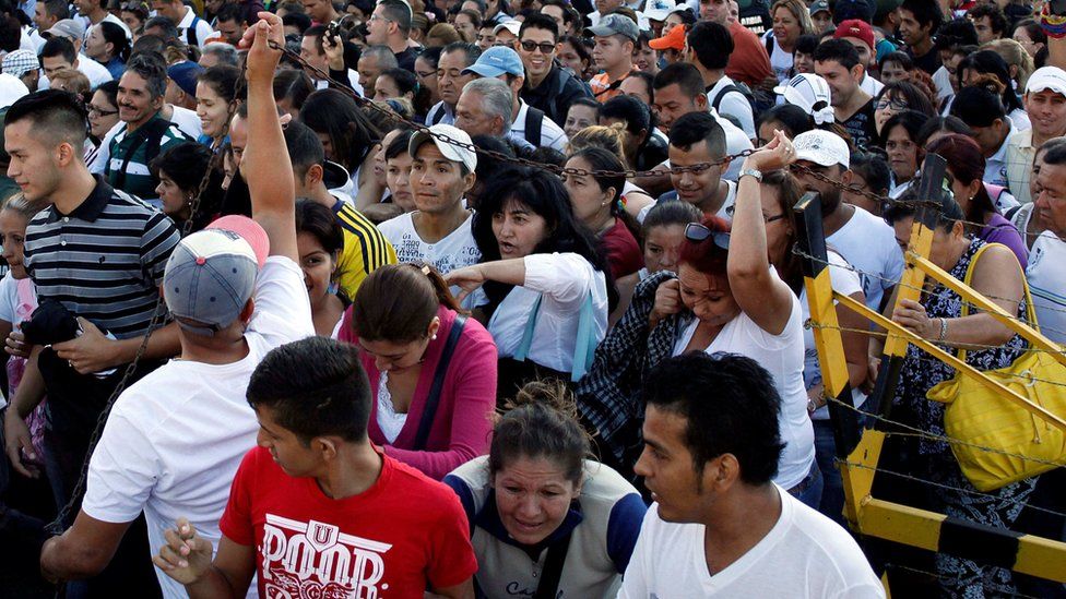 Venezuelan citizens push to each other trying to cross over the Simon Bolivar international bridge to Colombia to take advantage of the temporary border opening on 10 July