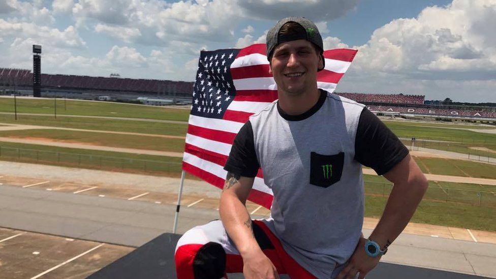 Facebook image of Alex Harvill kneeling near a US flag