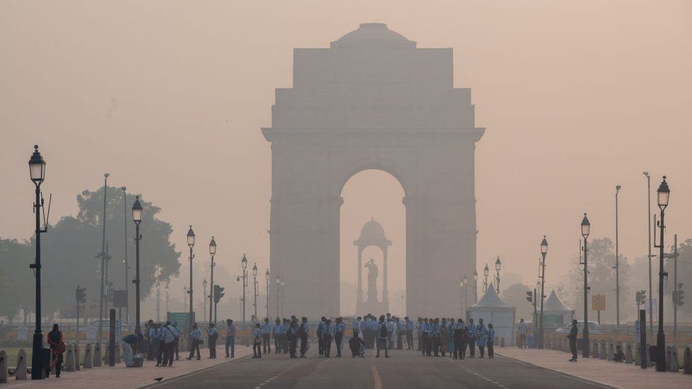 NEW DELHI, INDIA - 2023/11/01: India Gate with visitors seen shrouded in smog during the early morning. Air pollution in Delhi is primarily due to vehicles, industries, construction dust, waste burning, and crop residue burning. In winter, temperature inversions worsen the problem by trapping pollutants near the ground. (Photo by Pradeep Gaur/SOPA Images/LightRocket via Getty Images)