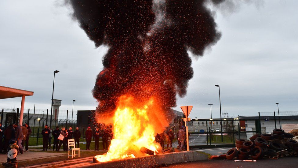 Waste burns as prison guards block the entrance to the penitentiary center of Alencon, in Conde-sur-Sarthe, northwestern France, on early March 6, 2019