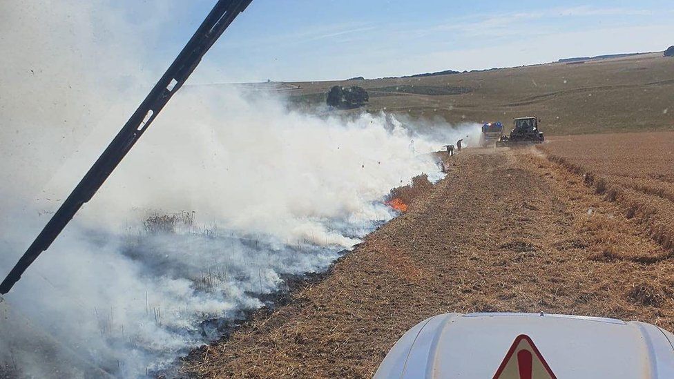 Farmer and firefighters beating back the flames