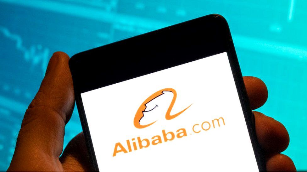 The Alibaba logo is displayed on a smartphone.