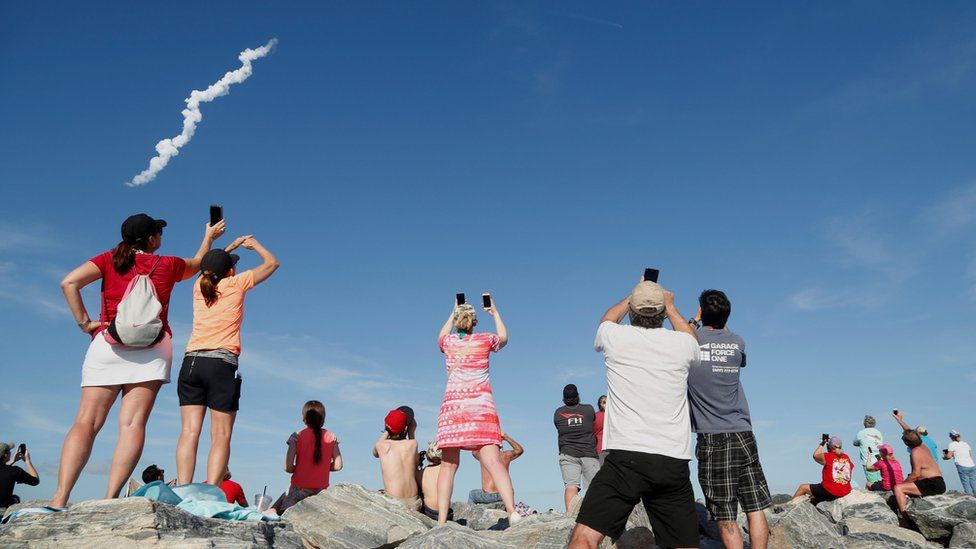 Spectators at Cocoa Beach in Florida watch the Falcon Heavy rocket launch