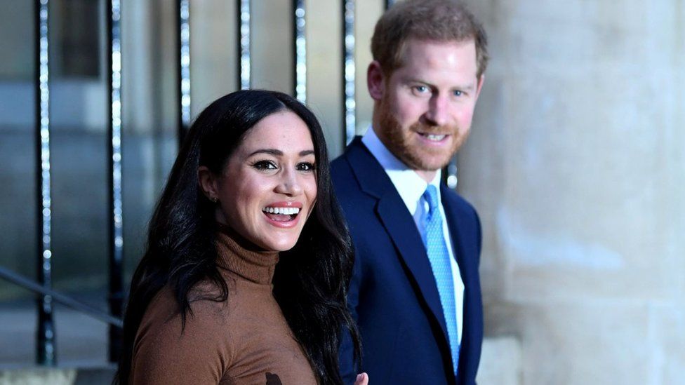 Prince Harry and his wife Meghan, Duchess of Sussex react as they leave after their visit to Canada House in London