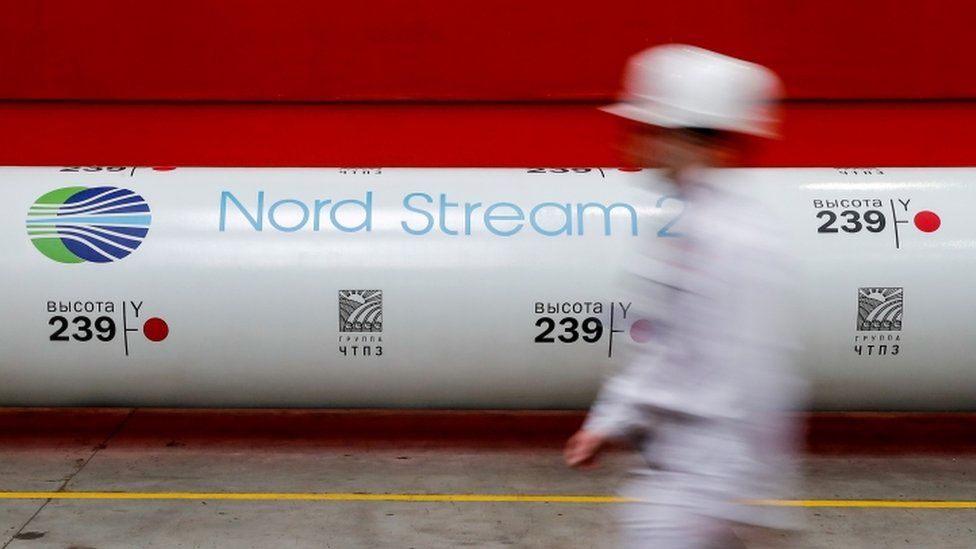 Person walks past section of Nord Stream pipeline