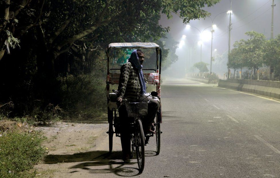 A rickshaw puller in smog