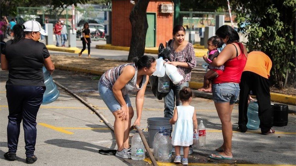 People collect water at the Park of the East, in Caracas, Venezuela, 12 March 2019
