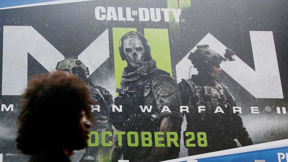 a person walks past the call of duty sign