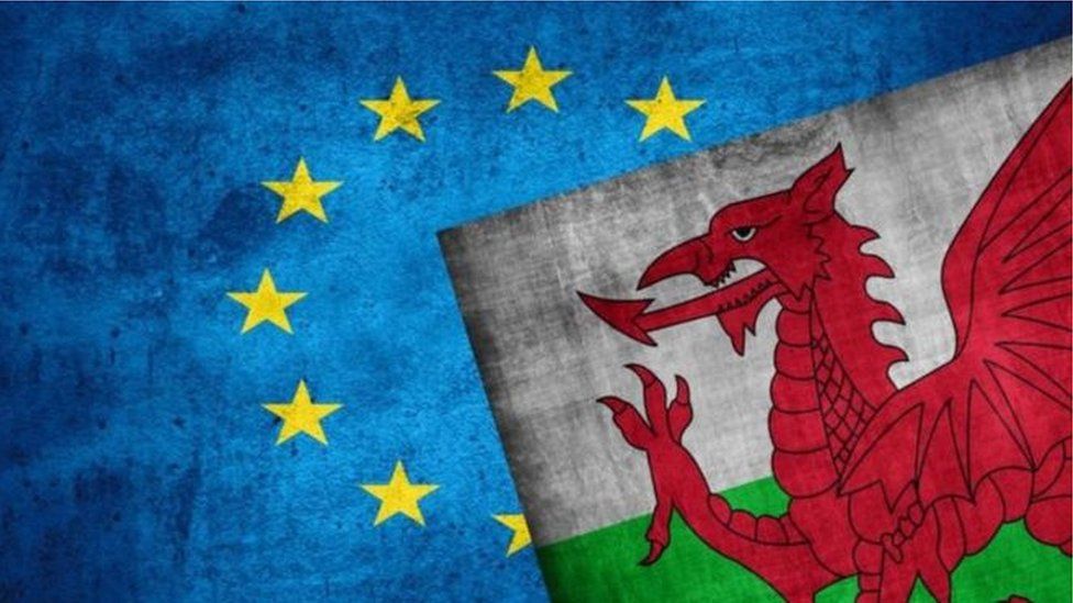 An EU flag and Welsh flag