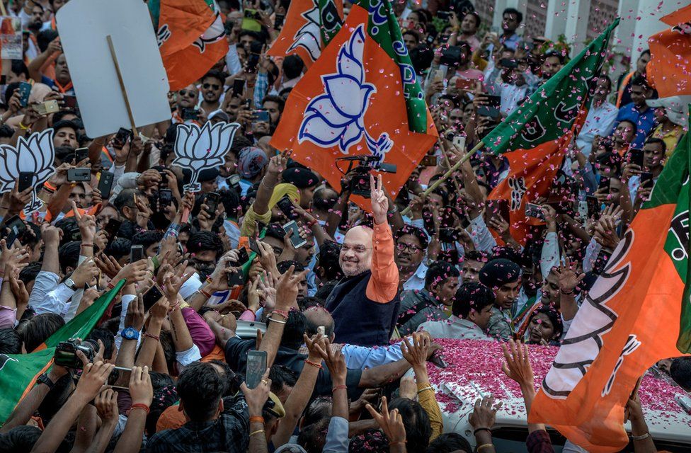 Amit Shah waves at BJP workers at party headquarters on May 23, 2019 after the election results gave a landslide win to Prime Minister Narendra Modi for the second five-year term