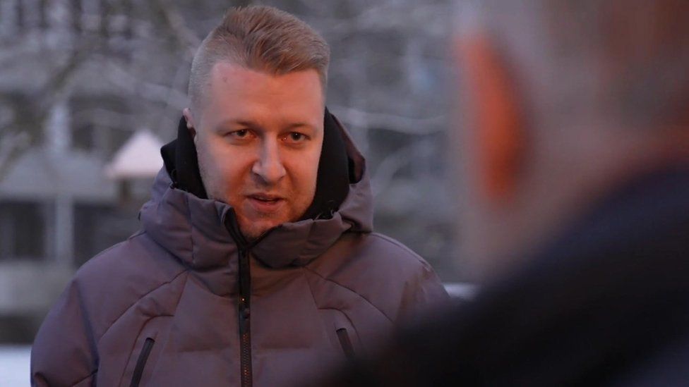 Povilas Bartkevicius speaking to the BBC outside his apartment building in Vilnius
