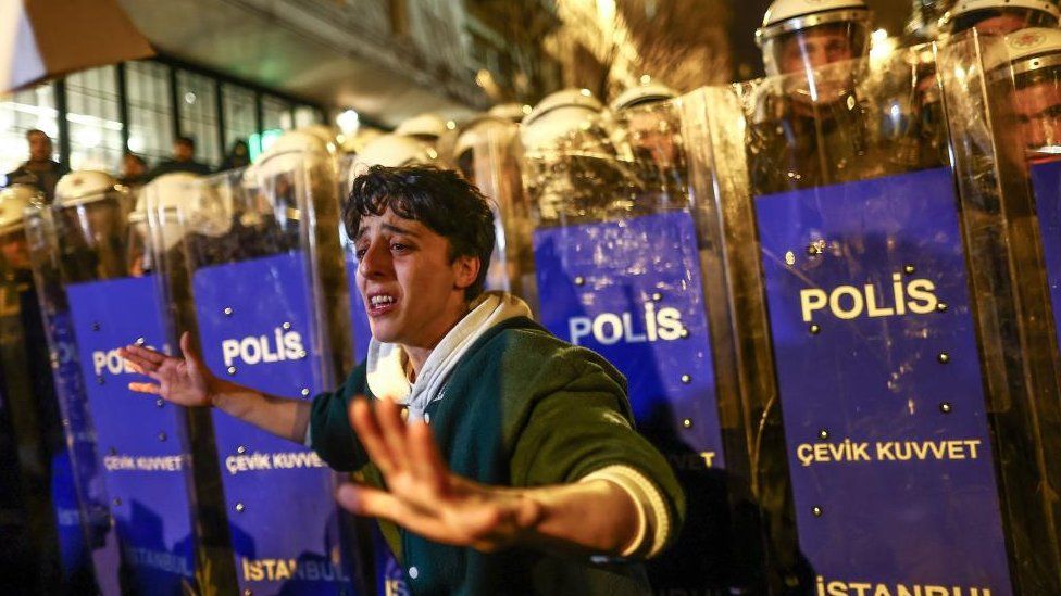 A protester stands before Turkish riot police as they block a street during a rally marking the International Women's Day in Istanbul, Turkey, 08 March 2023