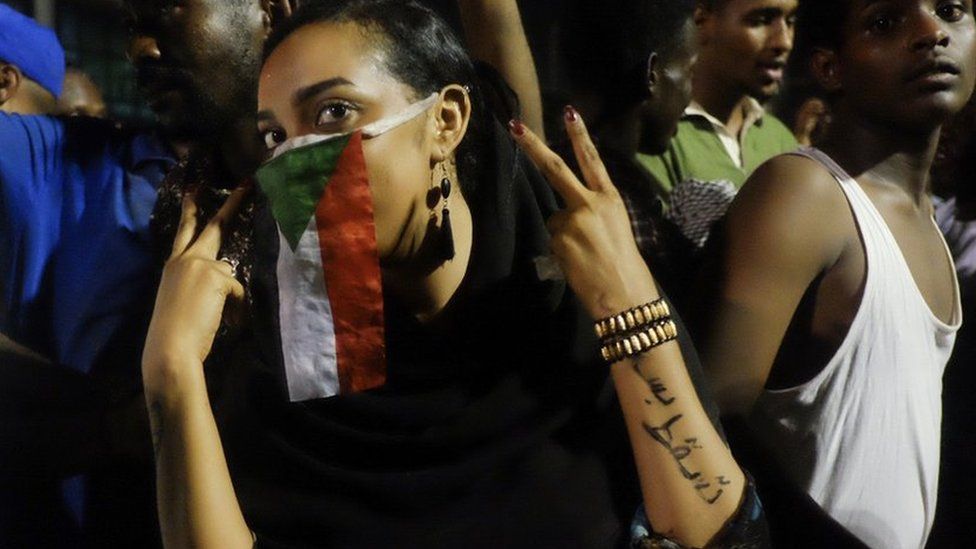 A woman with a Sudanese flag over her face at a sit-in at the military HQ in Khartoum, Sudan - Monday 8 April 2019