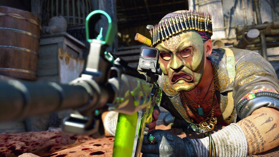 Персонаж в маске в Call of Duty лежит на земле с винтовкой наготове