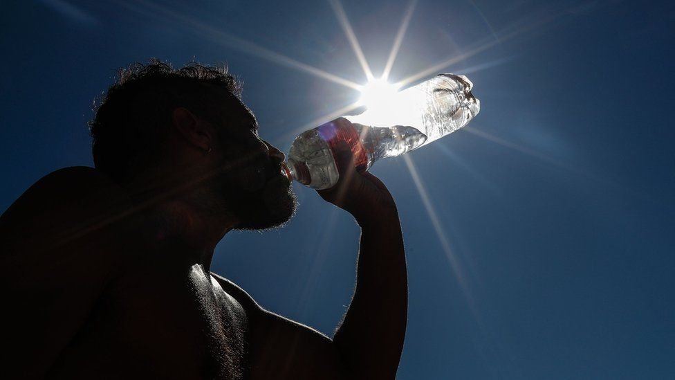 A man drinks water on Copacabana Beach in Rio de Janeiro, Brazil, 19 September 2023, during a heatwave.