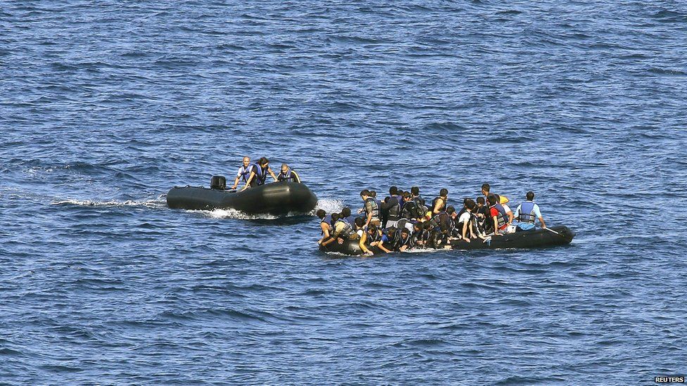 A dinghy with volunteer rescuers (L) approaches a dinghy with a broken engine overcrowded with Afghan refugees that drifted out of control between the Greek island of Lesbos and the Turkish coast