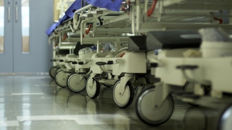 A hospital corridor with beds lined up in a row