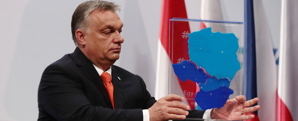 Hungarian Prime Minister Viktor Orban lifts a box depicting the V4 member countries on 21 June