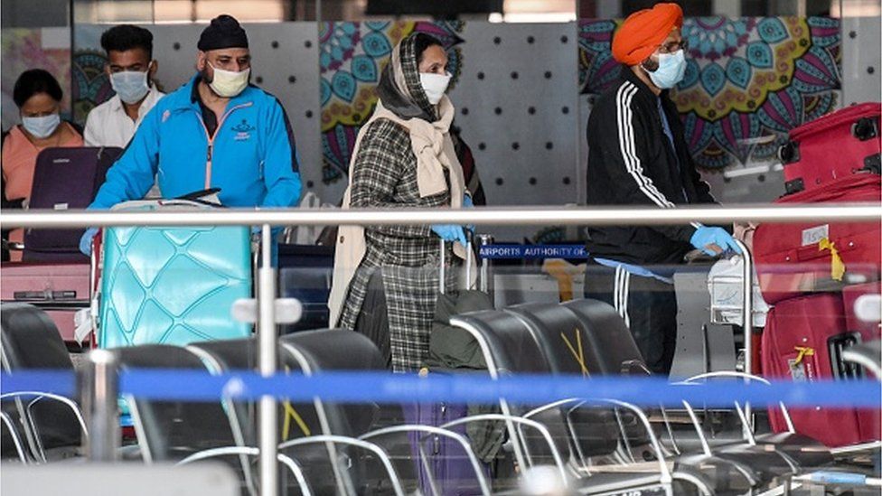 Indian nationals after returning from Vancouver city in Canada with a special flight queue before boarding buses taking them to a quarantine facility in Jalandhar amid concerns over the spread of the COVID-19 coronavirus, at Sri Guru Ram Dass Jee International Airport on the outskirts of Amritsar on May 22, 2020.