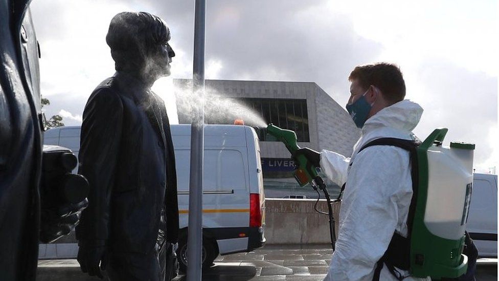 A worker sprays a Beatles statue in Liverpool