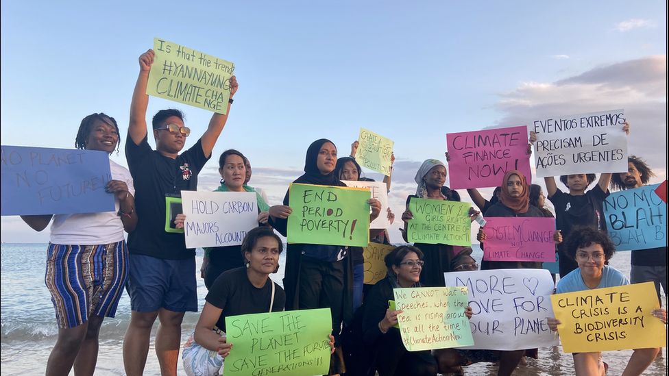 Молодые климатические активисты держат плакаты